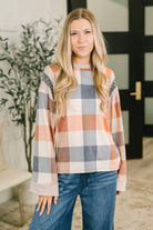 A relaxed casual top in a multi-color plaid design with a banded round neckline and wide sleeves.