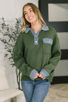 Green sweater top with denim collar and cuffs, featuring a patch pocket and relaxed fit.
