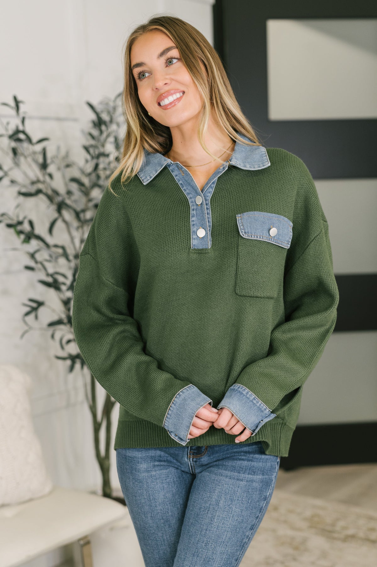 Green sweater top with denim collar and cuffs, featuring a patch pocket and relaxed fit.