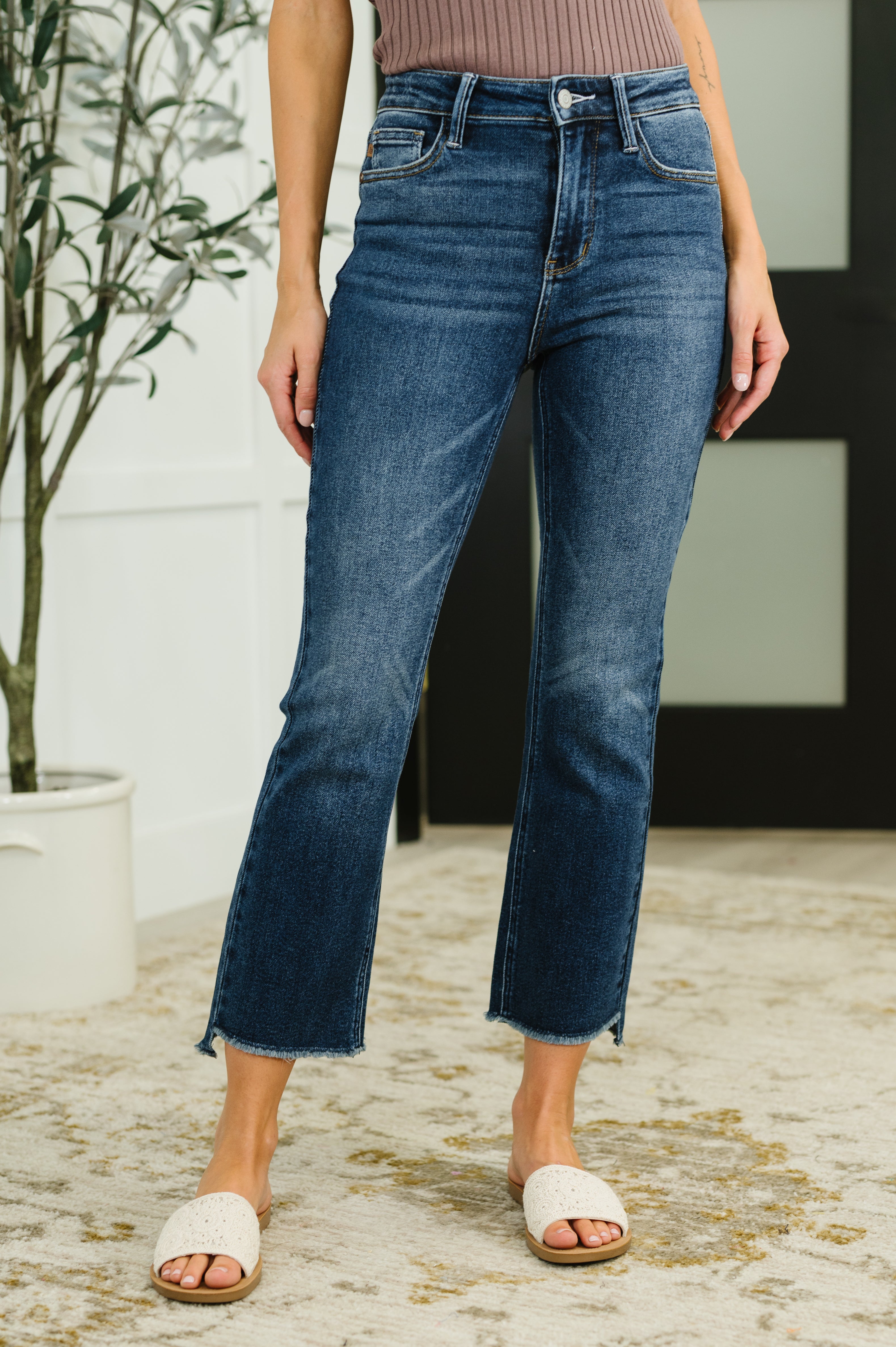 Person wearing blue jeans standing outdoors with a blurred background