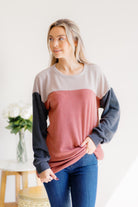 A woman wearing a multi-color pullover with a soft texture, featuring long sleeves and a relaxed fit.