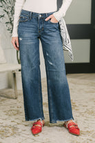 Model wearing blue low-rise baggy jeans with a bandana loop and distressed hem.