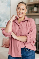 Woman wearing a pink shirt and blue jeans in a living room setting