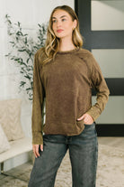 Brown mineral wash top with raglan sleeves, banded round neckline, and scooped hem, worn by a model.