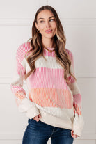 Woman wearing a colorful striped sweater against a white background