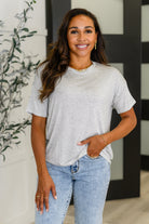 Woman wearing a striped shirt and jeans standing indoors with decorative elements in the background