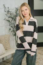 Relaxed black top with a collared split neck and drop shoulder design.