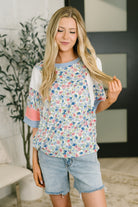 Color block top, floral knit shirt, ribbed short sleeve, women’s boutique fashion, exposed seam top, casual floral blouse, relaxed fit knitwear, contemporary women's style.