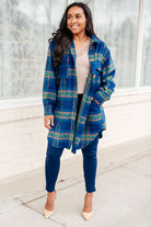Woman wearing a blue and green plaid coat with button front and collared neckline.