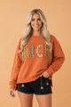 Halloween sweatshirt, witchy aesthetic clothing, plaid patchwork top, exposed seam sweatshirt, burnt orange autumn sweater, spooky season apparel, women's fall fashion.