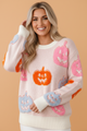 Halloween sweater, pastel pumpkin knit, jack-o-lantern crewneck, cozy fall fashion, women's holiday sweater, pink Halloween outfit, festive knitwear, pumpkin spice style.