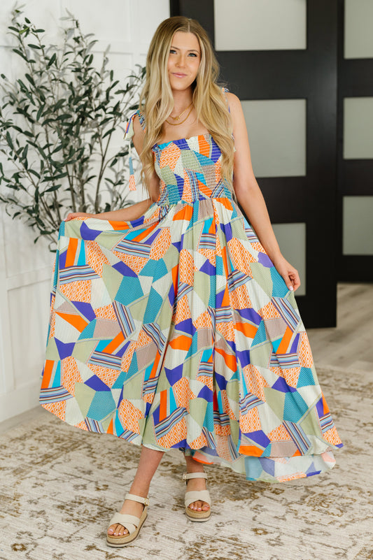 Woman wearing a colorful geometric patterned dress indoors.