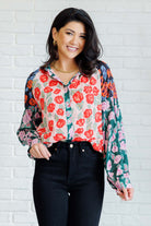 Woman wearing a floral blouse with a white brick wall background