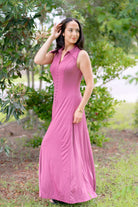 Woman wearing a grape-colored, sleeveless, button-front, flowy dress standing outdoors.