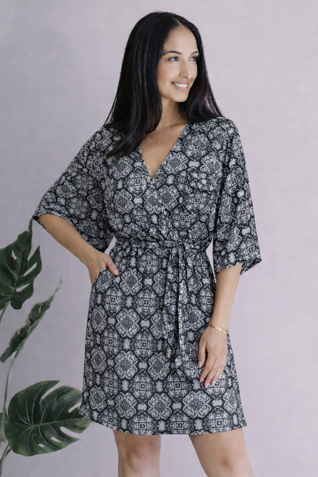 Black dress with kimono sleeves, surplice neckline, and self-tie belt, worn by a model.