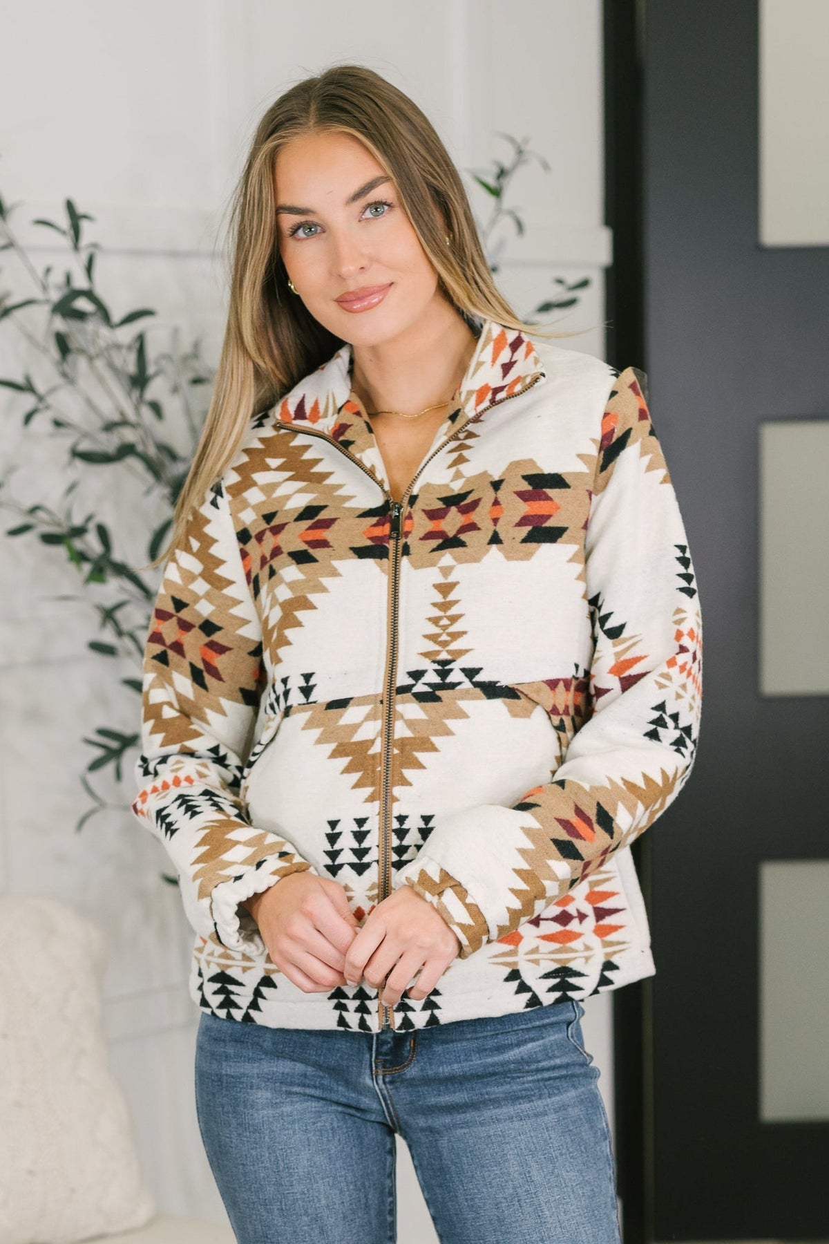 A woman wearing a multicolor brushed fleece jacket with a geometric pattern, full zip, and high neck.