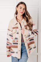 Model wearing a shacket with Aztec pattern and sherpa fleece accents.