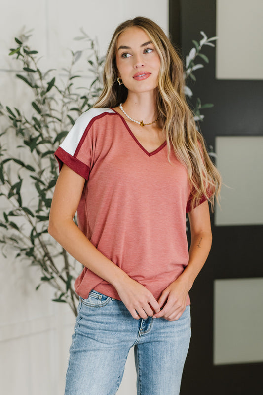 Woman wearing a red and white striped shirt with blue jeans indoors.