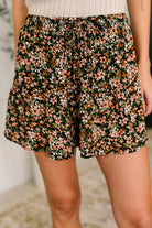 Woman wearing Floral shorts with a blurred background.