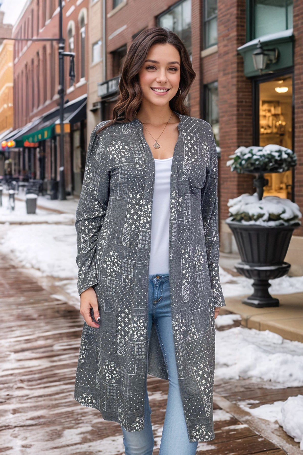 Woman wearing a long grey duster with subtle Aztec patterns, open front, and soft fabric.