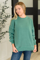 Woman wearing a green sweatshirt in an indoor setting