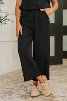 Woman wearing black pants and beige shoes indoors
