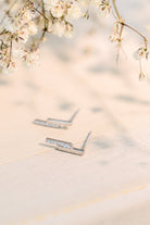 Sterling silver earrings with a stepped design and cubic zirconia accents on a soft background.