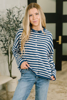 Model wearing a navy striped button-down sweater with a collared neckline and relaxed fit.