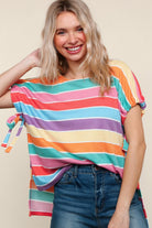 Woman wearing a colorful striped shirt with a plain background