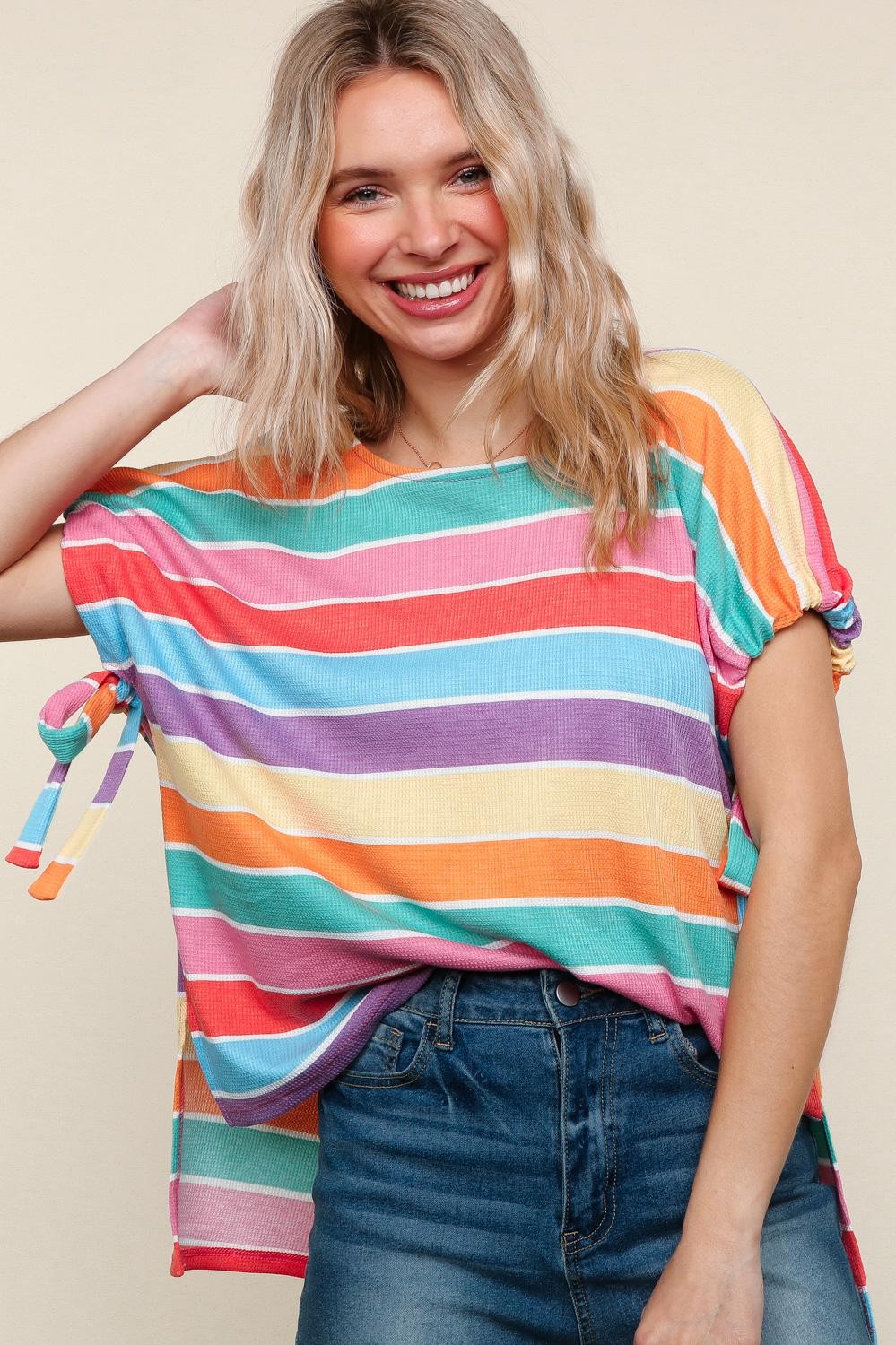 Woman wearing a colorful striped shirt with a plain background
