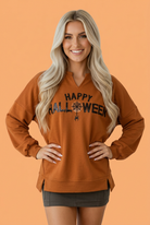 Halloween top, sequin graphic sweatshirt, women’s fall fashion, Halloween sparkle shirt, orange long sleeve top, notched neck sweatshirt, festive boutique apparel, pumpkin spice outfit.