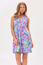 A woman wearing a sleeveless, knee-length multicolored dress with a mandarin collar and pleated detail on the back.