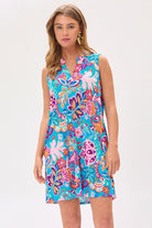 Woman wearing a sleeveless, floral tank dress in blue with a mandarin collar.