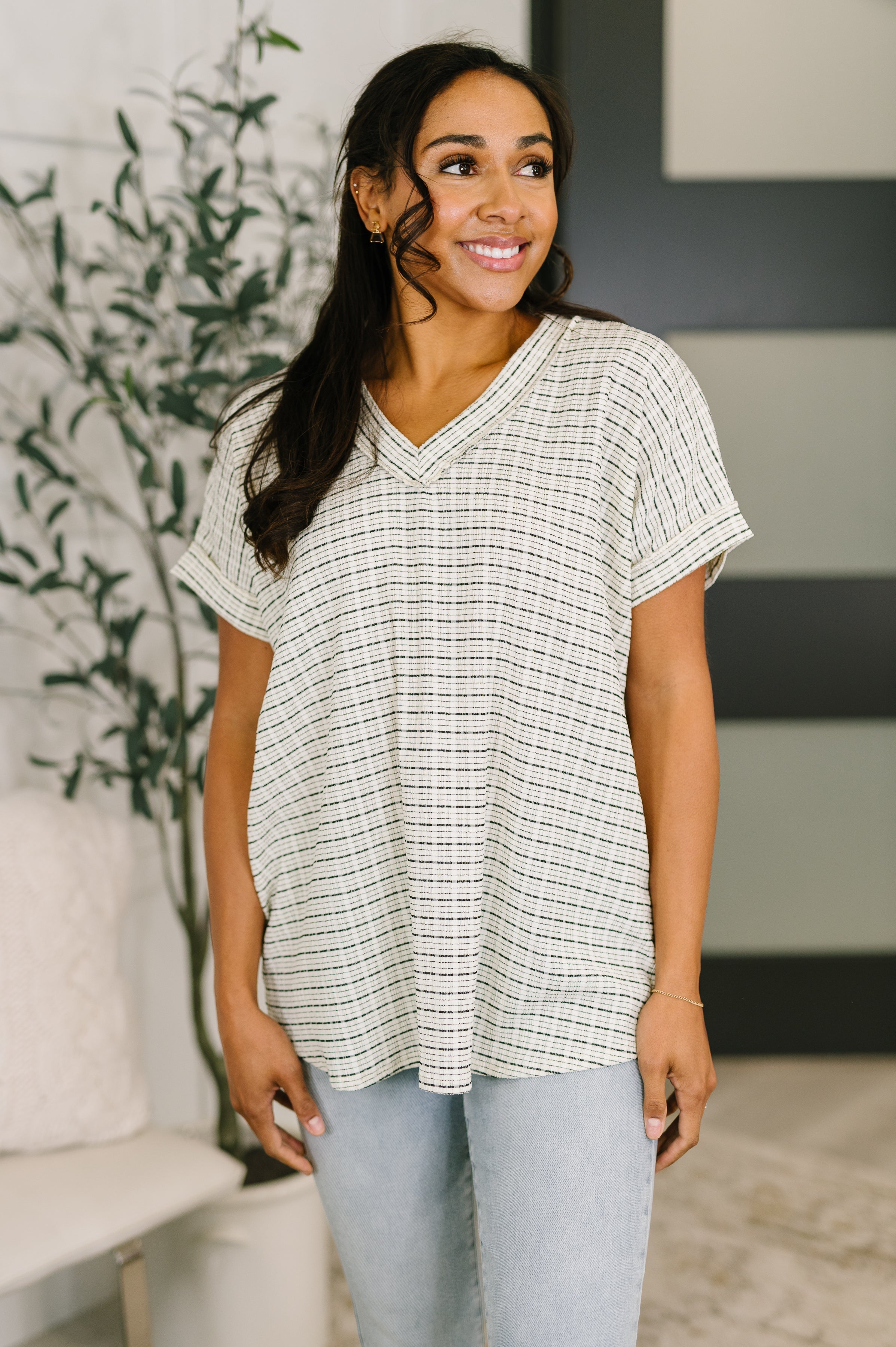 V-neck top, textured knit tee, relaxed fit blouse, women's casual tops, exposed seam shirt, stretchy knit top, short sleeve v-neck, effortless everyday style.