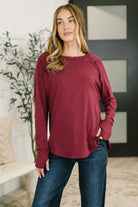 Raglan sleeve top in rich cabernet with a banded round neckline and scooped hem.