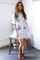 Woman wearing a striped dress with colorful roller skate designs indoors