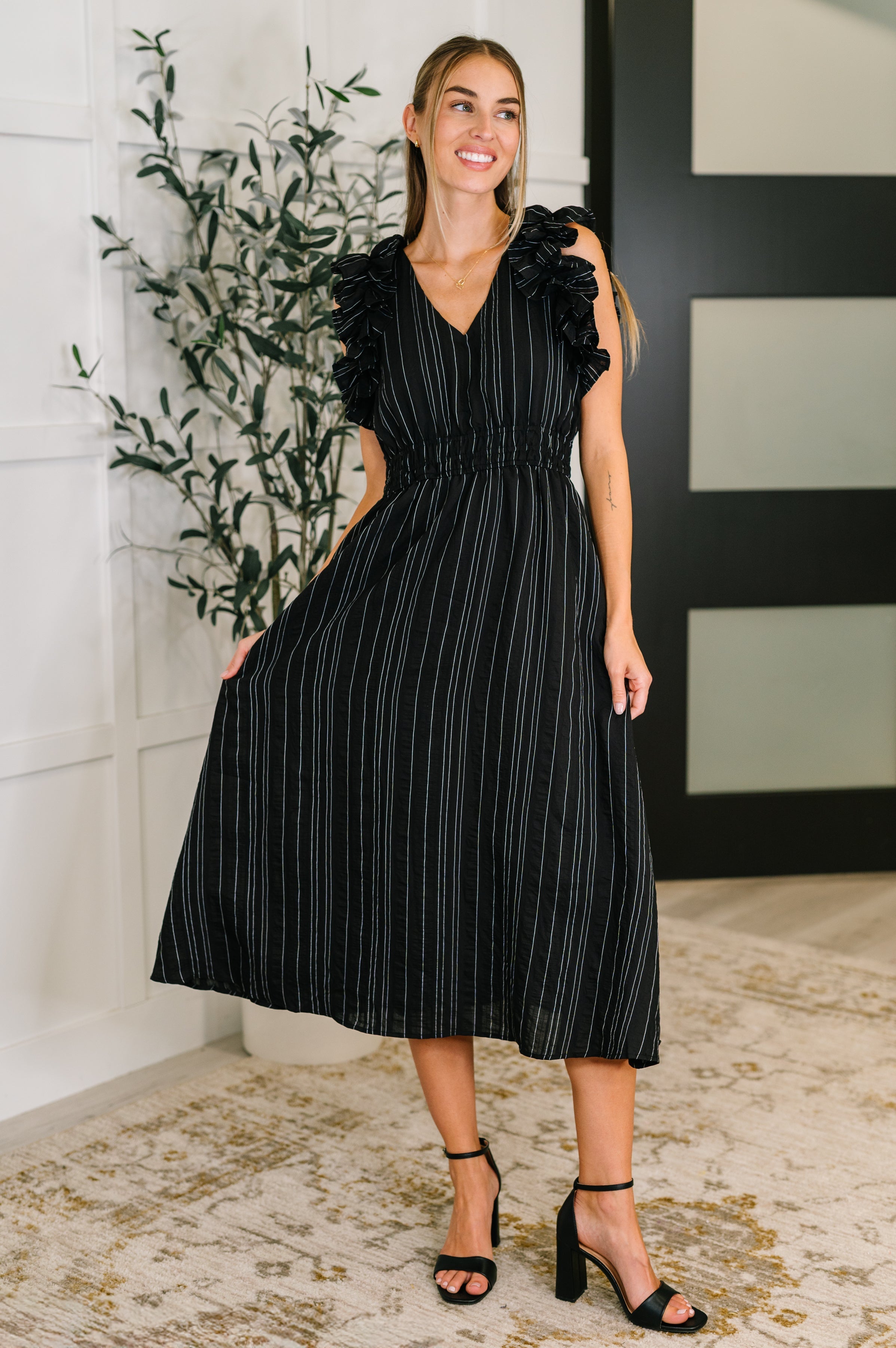 Black pinstripe dress, ruffle sleeve midi, V-neck work dress, professional women's attire, day-to-night fashion, lightweight woven dress, feminine office wear, elegant pinstripe midi.