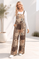 Patchwork overalls in chocolate and tan with florals, checks, and plaids, featuring a wide leg and bib front.