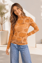 Sheer mesh top with an all-over pumpkin print, featuring a mock neck and long sleeves.