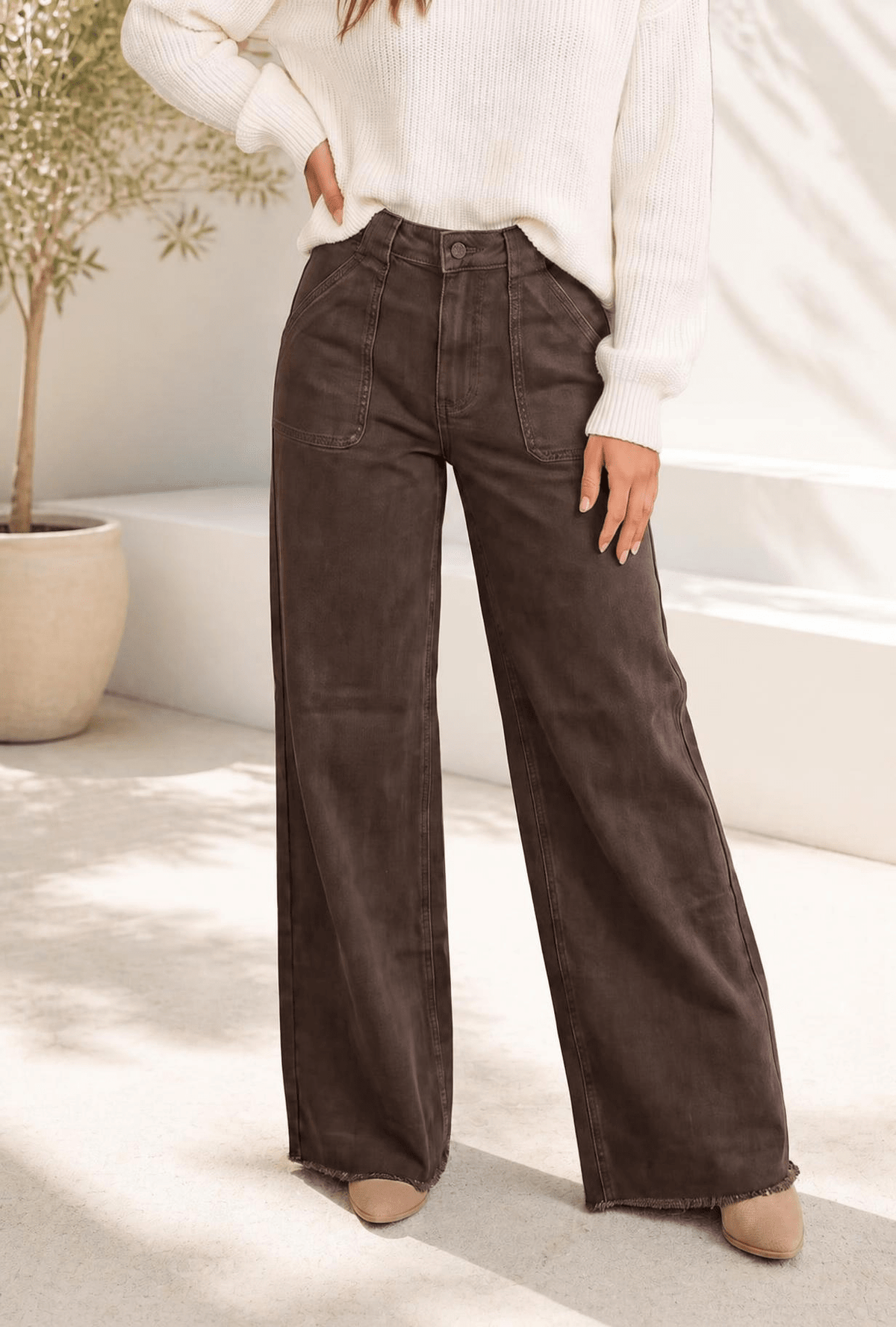 Wide leg high rise jeans in washed brown denim with large patch pockets and a raw hem.