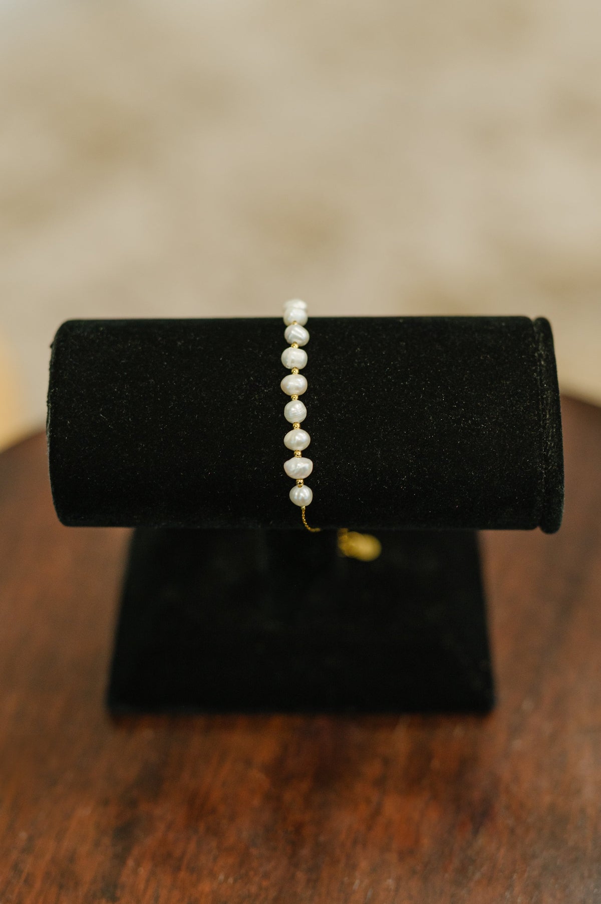 Pearl bracelet on a black velvet stand with a blurred background