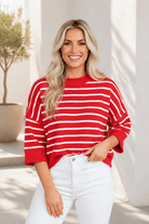 Red and white striped knit top with drop-shoulder design and ribbed detailing.