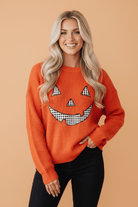 Halloween sweater, pumpkin sweater, jack-o-lantern knit, oversized fall sweater, gingham patch sweater, boutique autumn apparel, women's holiday sweater, orange knit top.